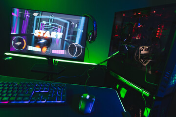Composite of computer, keyboard with video game accessories with copy space on neon background