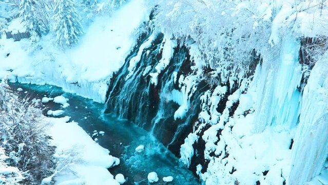 Shirahige Waterfall with Snow in winter, Biei river flow into Blue Pond. landmark and popular for attractions in Hokkaido, Japan. Travel and Vacation concept