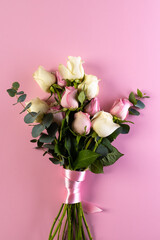 Obraz premium Vertical image of pink and white rose flowers and copy space on pink background