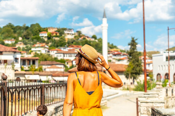 Fototapeta na wymiar A young woman walking through the town of Berat in Albania on vacation, the city of a thousand windows