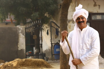 Mid-Aged man in Rural Environment wearing kurta-pajama which is traditional Dress for men in North India in day time holding walking cane. - obrazy, fototapety, plakaty
