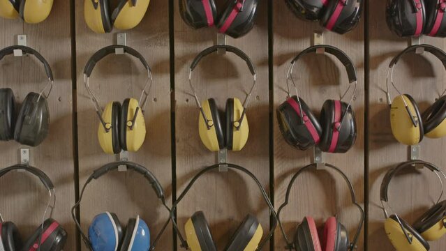Tilt up of hearing protection ear muffs hanging on a wall