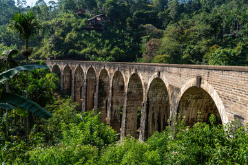 Fototapeta na wymiar Train on the Nine Arches Demodara Bridge or the Bridge in the sky. Nine Arches Bridge is located in Demodara near Ella city, Sri Lanka.
