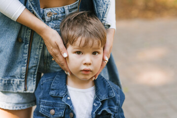 Loving mother hugs her son. A large portrait of a little boy and his mother's hands