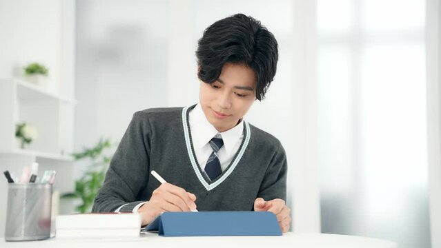 タブレットで勉強する男子学生