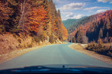 Driving a car along a mountain winding road. Empty road. View from a car to the autumn mountain landscape