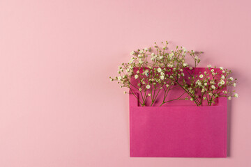 White flowers in pink envelope and copy space on pink background