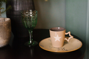 Christmas dishes. A cup of tea and a green glass on the table