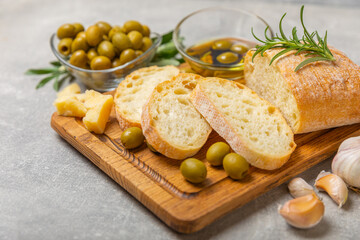 Ciabatta and olives. Fresh italian ciabatta bread with herbs, olive oil,parmesan and pesto sauce, olives on wooden background, top view, copy space.Flatley. Place for text. copy space.