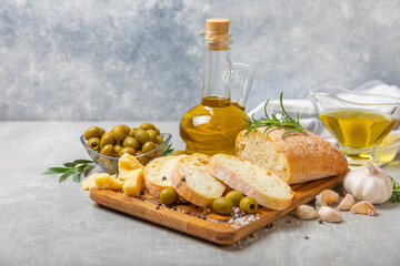 Ciabatta and olives. Fresh italian ciabatta bread with herbs, olive oil,parmesan and pesto sauce, olives on wooden background, top view, copy space.Flatley. Place for text. copy space.