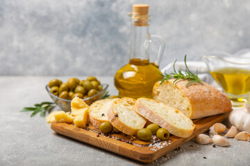 Ciabatta and olives. Fresh italian ciabatta bread with herbs, olive oil,parmesan and pesto sauce, olives on wooden background, top view, copy space.Flatley. Place for text. copy space.