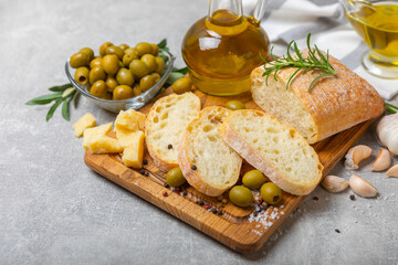Ciabatta and olives. Fresh italian ciabatta bread with herbs, olive oil,parmesan and pesto sauce, olives on wooden background, top view, copy space.Flatley. Place for text. copy space.