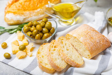 Ciabatta and olives. Fresh italian ciabatta bread with herbs, olive oil,parmesan and pesto sauce, olives on wooden background, top view, copy space.Flatley. Place for text. copy space.
