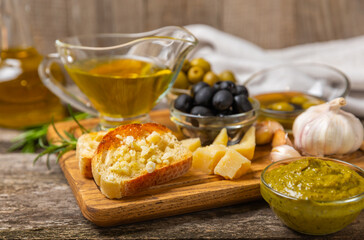 Ciabatta and olives. Fresh italian ciabatta bread with herbs, olive oil,parmesan and pesto sauce, olives on wooden background, top view, copy space.Flatley. Place for text. copy space.