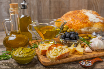 Ciabatta and olives. Fresh italian ciabatta bread with herbs, olive oil,parmesan and pesto sauce, olives on wooden background, top view, copy space.Flatley. Place for text. copy space.