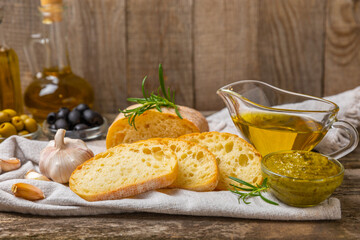 Ciabatta and olives. Fresh italian ciabatta bread with herbs, olive oil,parmesan and pesto sauce,...
