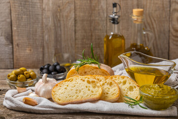 Ciabatta and olives. Fresh italian ciabatta bread with herbs, olive oil,parmesan and pesto sauce,...