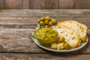 Ciabatta and olives. Fresh italian ciabatta bread with herbs, olive oil,parmesan and pesto sauce, olives on wooden background, top view, copy space.Flatley. Place for text. copy space.