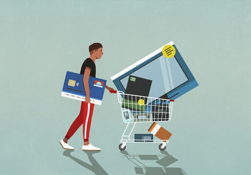 Male consumer with credit card pushing shopping cart with technology merchandise
