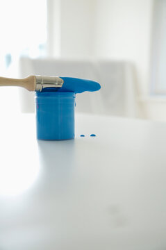 Blue paint tester and dripping paint brush

