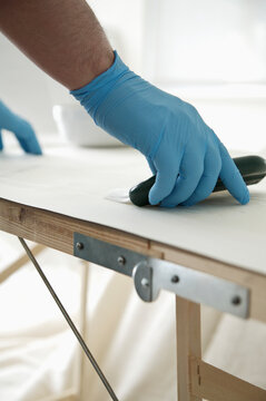 Close up of man's hands applying wallpaper paste

