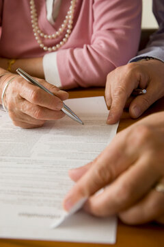 Close up of man and woman hands signing documents

