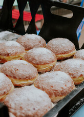 Sweet polish traditional donuts in plastic crate with sugary sprinkle