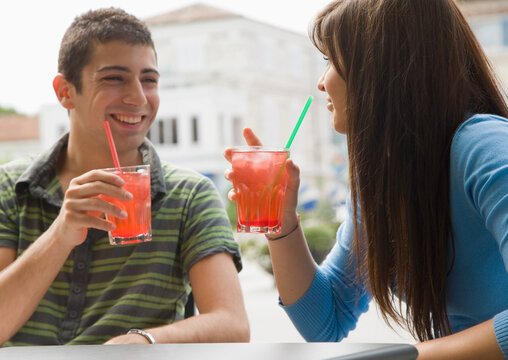 Portrait of young couple sitting and drinking cocktails
