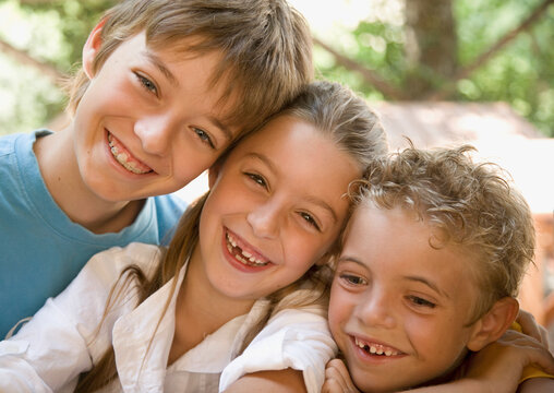 Portrait of three young children laughing
