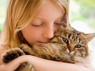 Close up of young girl hugging kitten
