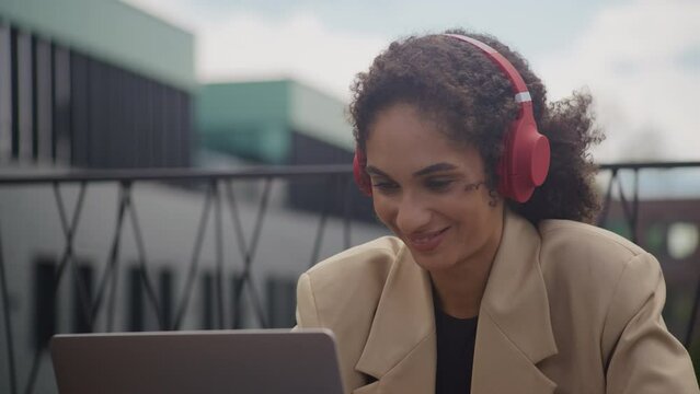 Woman in Headphones Listening to Podcast on Laptop