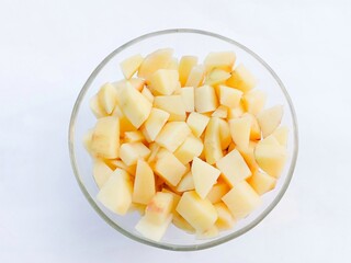 Diced raw potatoes in a glass bowl on a white background. vegetables. cooking preparation. healthy living. bowl of potato