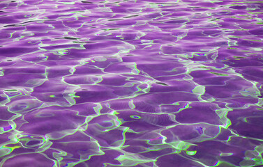 Stunning surreal pop art of purple colored water surface reflecting with sunlight