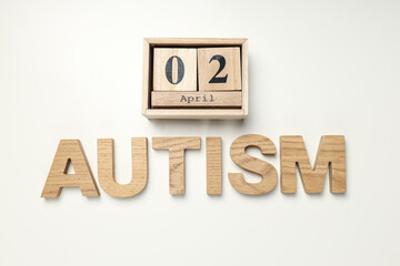The word "autism" in wooden letters on a light background.World autism awareness day concept