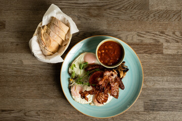English Breakfast with fried eggs, bacon, Hungarian sausage, mushrooms, baked beans and tomatoes