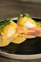 Eggs Benedict with salmon on a wooden table