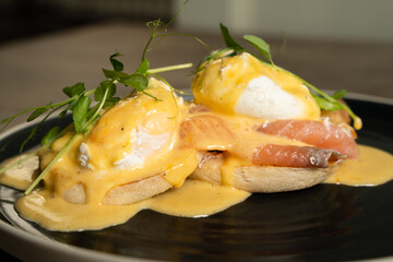 Eggs Benedict with salmon on a wooden table