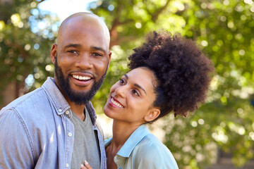 Portrait Of Loving Couple Standing Outdoors In Garden Park Or Countryside Hugging