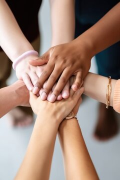 cropped shot of a group of unrecognizable friends connecting the hands together in unity