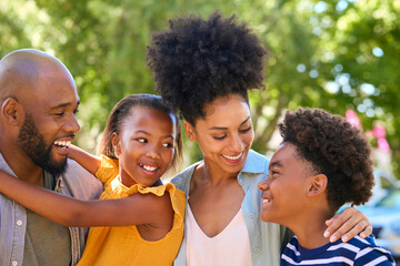 Portrait Of Smiling Family Standing In Summer Garden Or Countryside Smiling At Camera