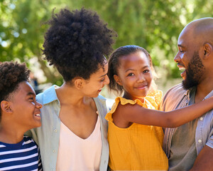 Portrait Of Smiling Family Standing In Summer Garden Or Countryside Smiling At Camera