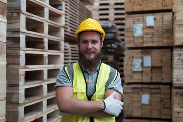 Portrait of male warehouse worker wearing safety uniform working in wooden warehouse storage. Male...