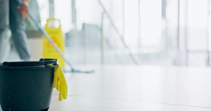 Cleaning, person and mop on floor of office for cleaner service, professional janitor and maintenance. Manual labor, wet sign and worker with tools for hygiene, disinfection and washing in workplace