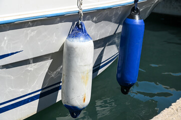Rubber fender hanging on sailing boat. Rubber bumpers.