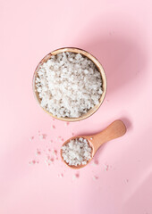 Mineral-rich sea coarse salt on a pink background. Salt harvested in the marshes of the Île de Ré in France