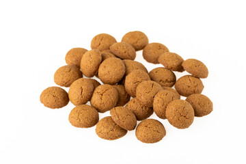 Kruidnoten are crunchy biscuits with gingerbread spices, which are often eaten during the Sinterklaas celebration in the Netherlands. Pile of spice nuts from above on a white background.