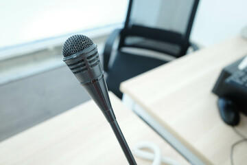 Close up of a black microphone on a desk.