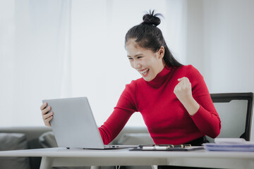 Successful Asian woman at work, beautiful smiling, happy working with laptop and smart phone in office at home. modern work