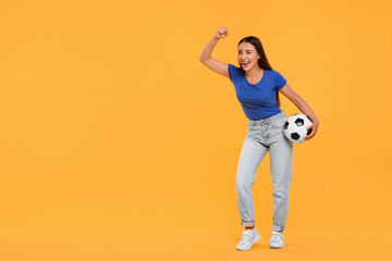 Happy fan with soccer ball celebrating on yellow background, space for text