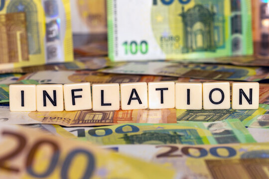 Symbolbild Inflation: Eurobanknoten und Buchstabenwürfel die das Wort Inflation anzeigen